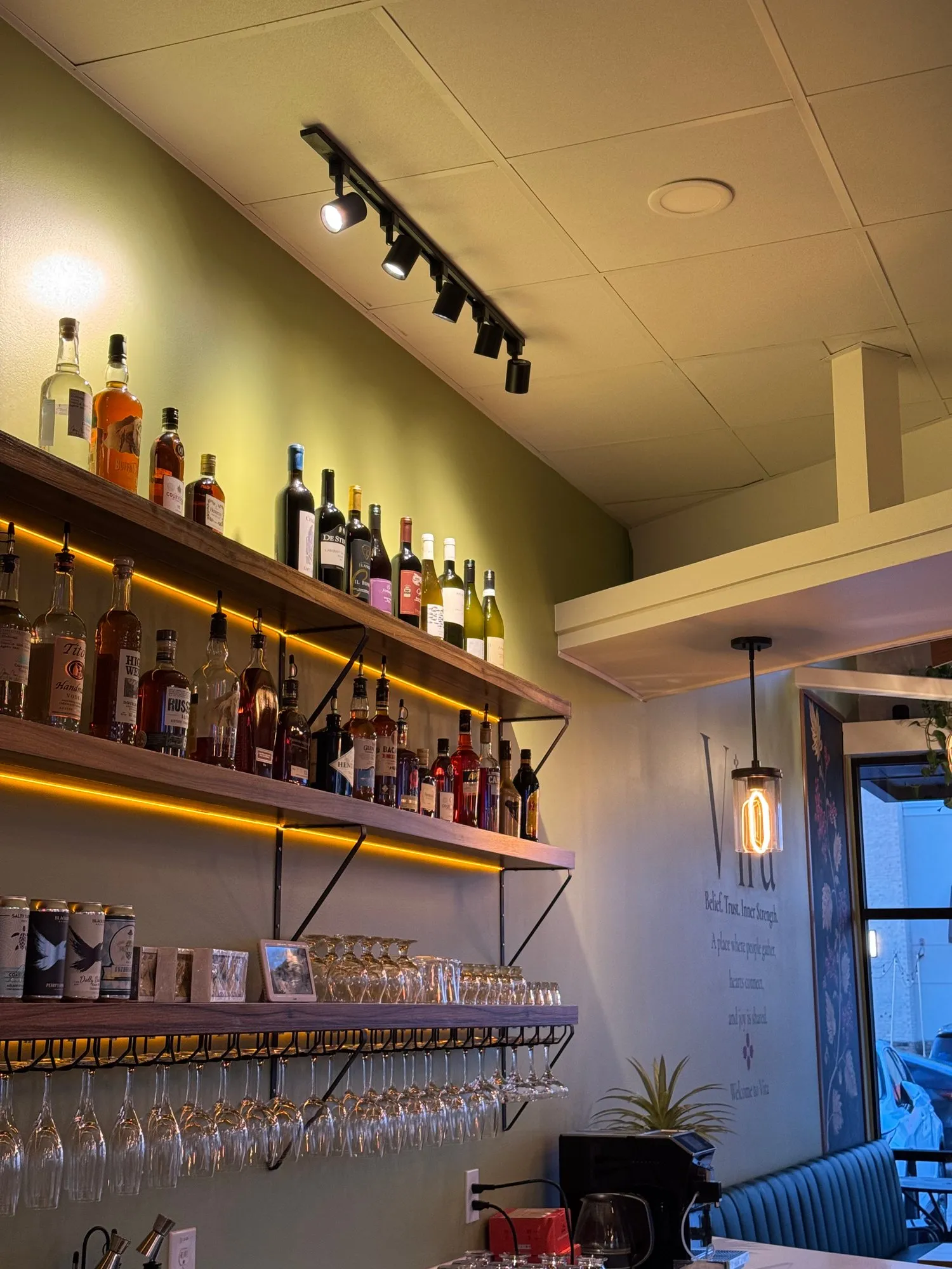 Lit shelves of wine and spirits above the bar, in the evening