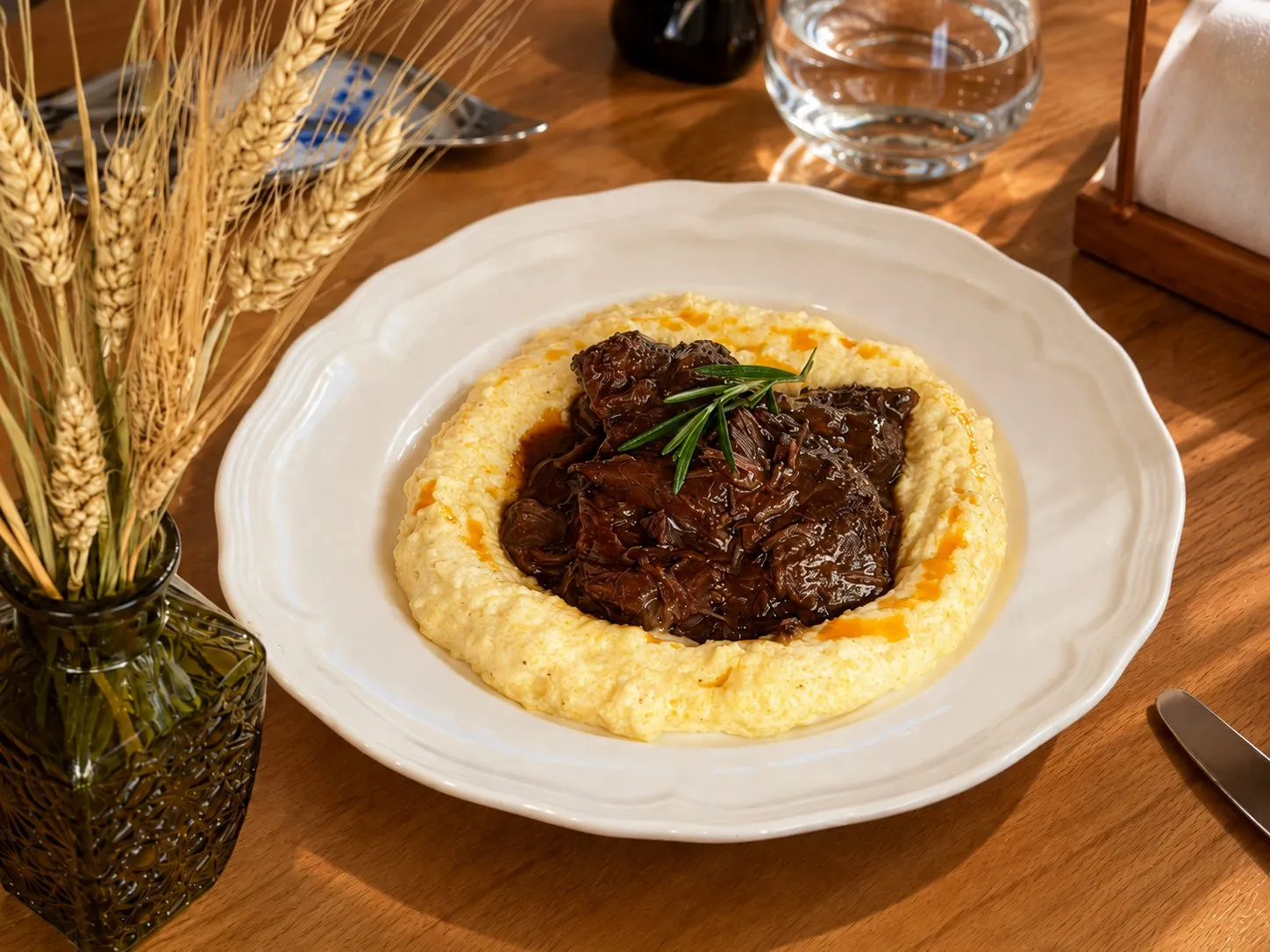 Beef cheeks braised in red wine over banosh, with a sprig of rosemary