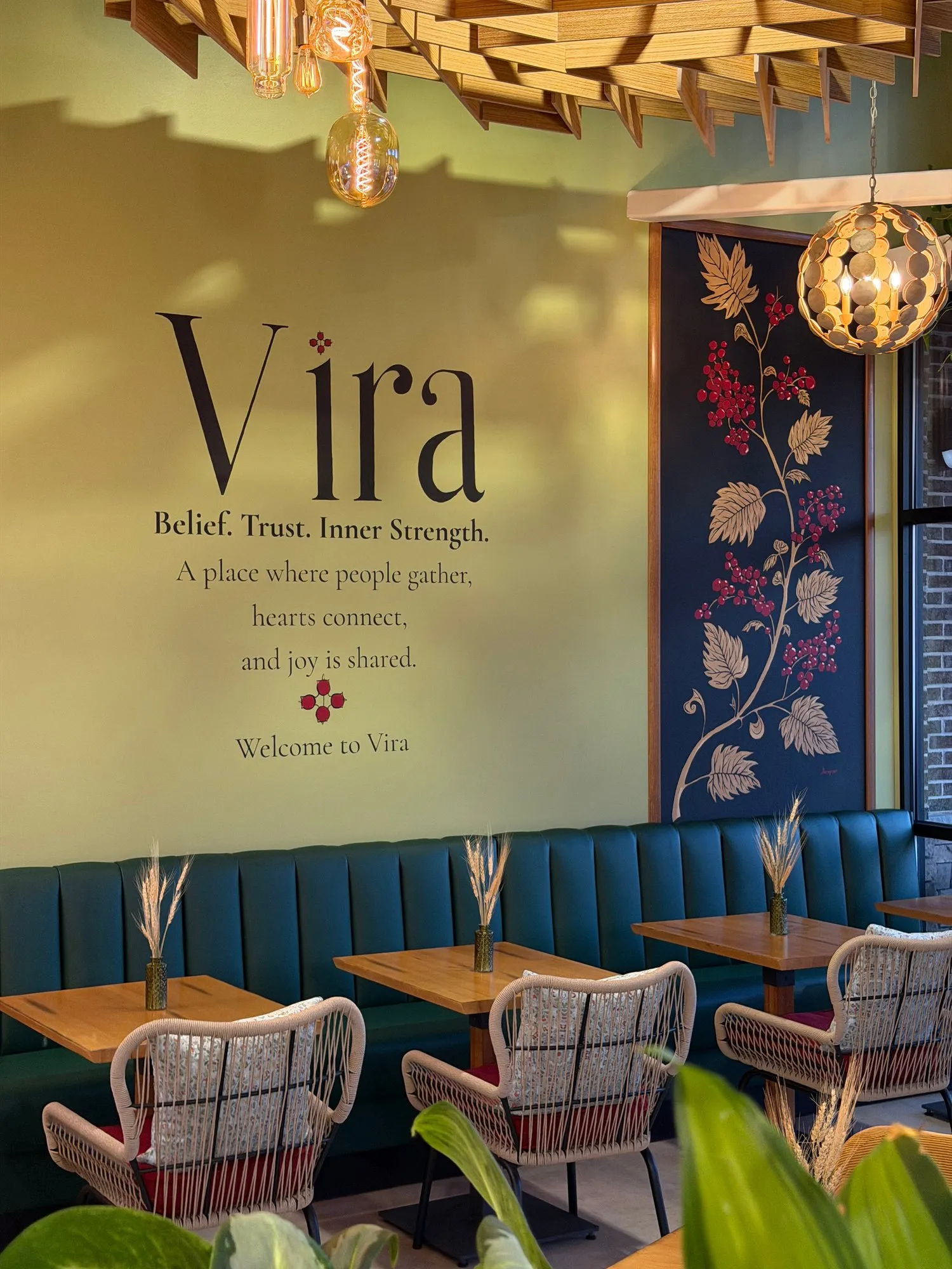 The Vira wall — "Belief. Trust. Inner Strength." — beside a mural of kalyna berries