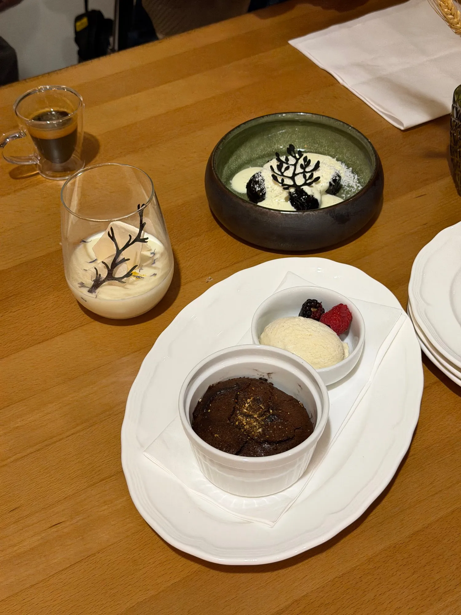 Chocolate fondant with a scoop of ice cream and berries, prunes in port wine and an espresso behind it