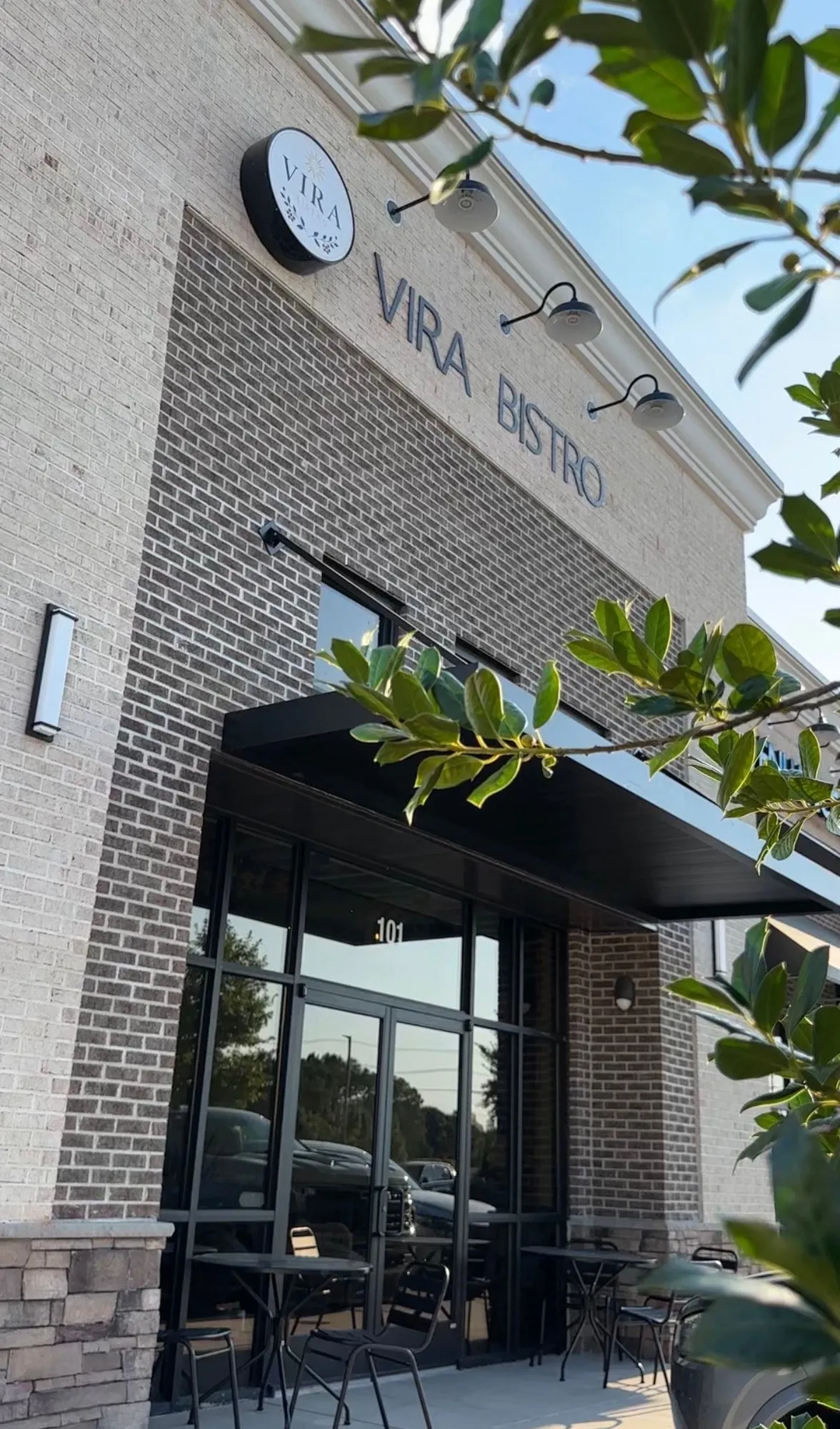 The Vira Bistro storefront on Rogers Branch Road, with its round sign and black awning